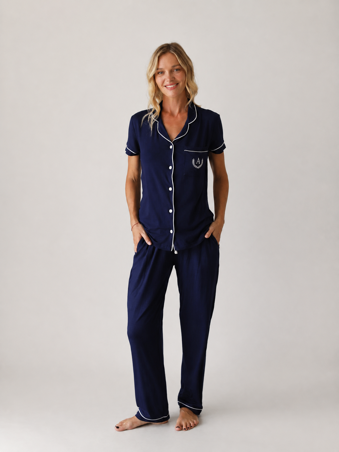 Model wearing a navy short-sleeve pajama set with white piping