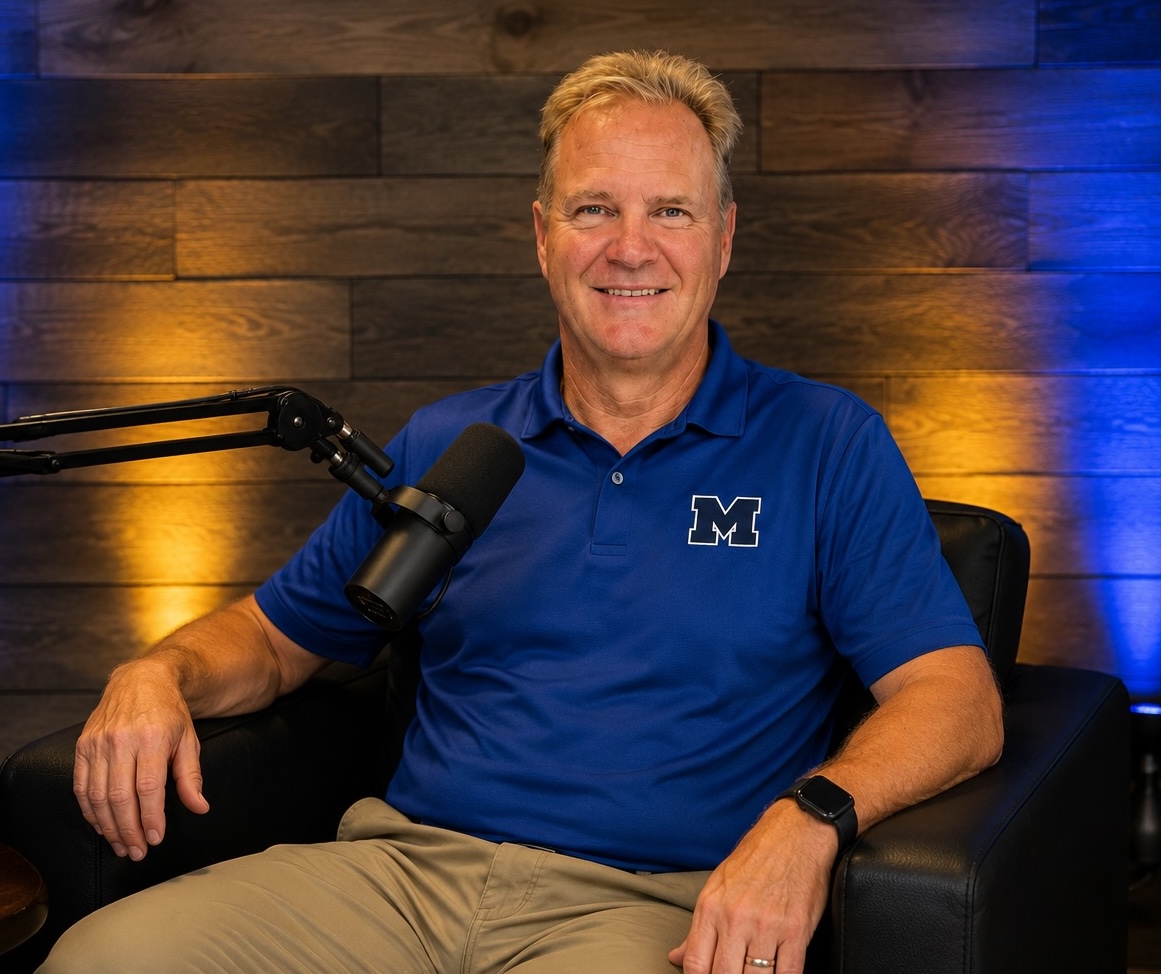 Coach Cal Boyd behind a podcast microphone in the studio