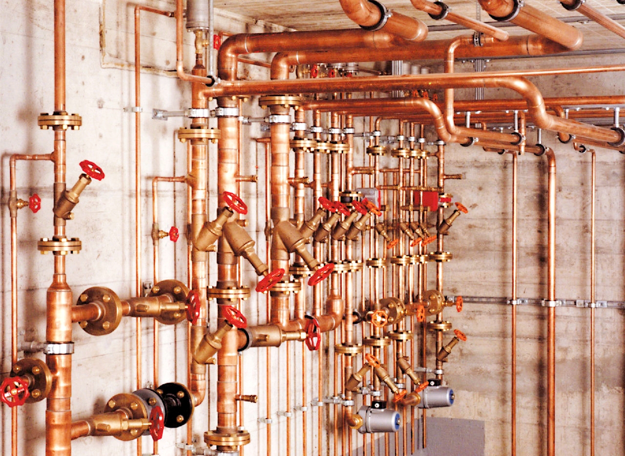 Professional copper pipe plumbing installation with brass fittings and valves