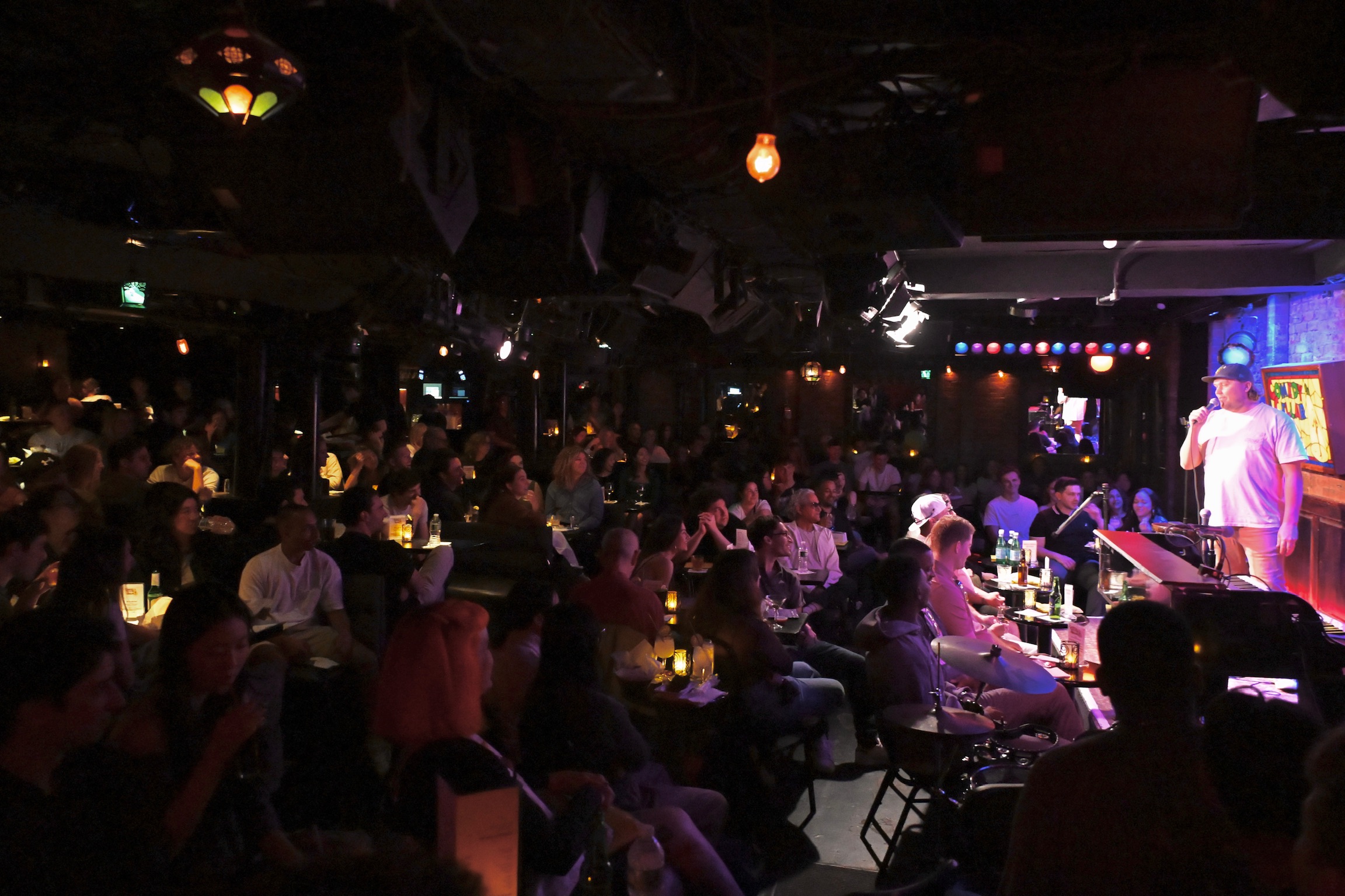 The packed crowd at the Comedy Cellar watching a comedian perform