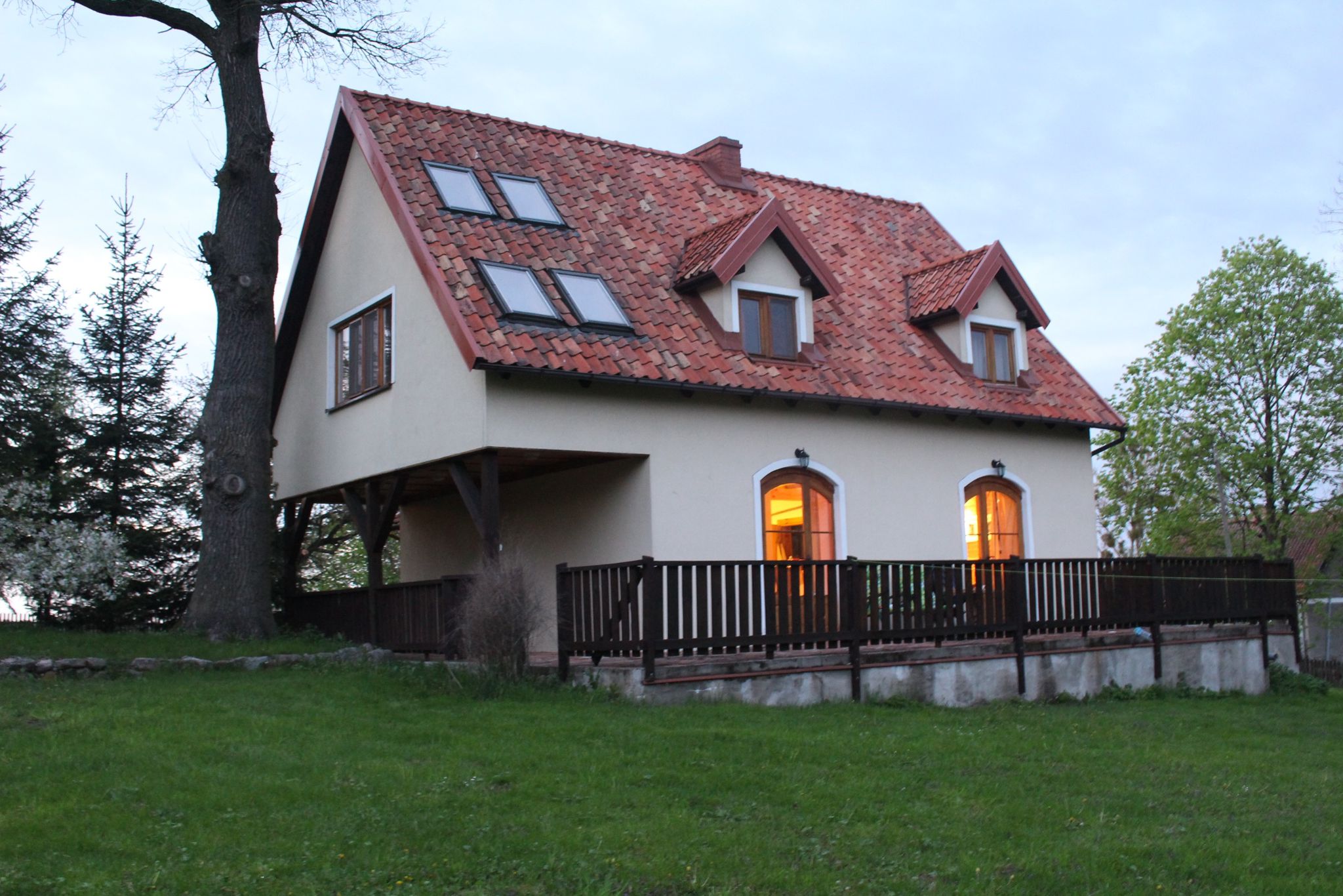 Dom o zmierzchu z oświetlonymi oknami