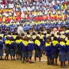 Großes Schulfest mit Hunderten Kindern in blauen Uniformen auf dem Schulplatz