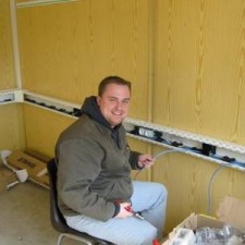 Mann installiert Technik im Innenraum des Containers