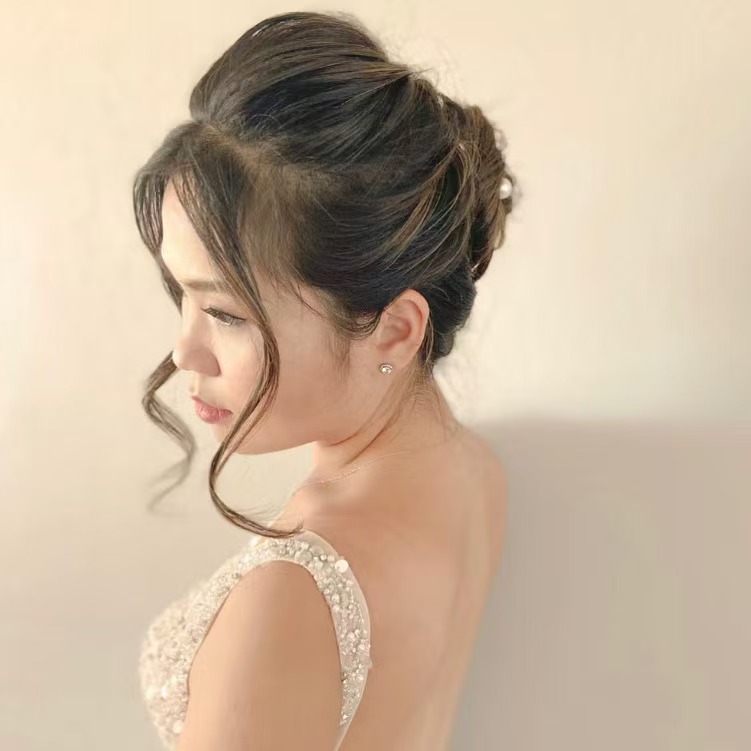 Elegant high bun bridal updo with sparkly dress