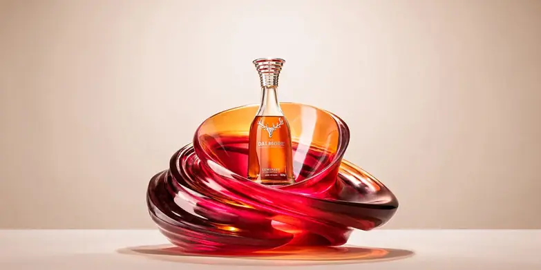 Dalmore Luminary decanter nestled in a swirling amber glass sculpture