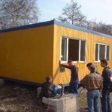 Handwerker montieren Fenster am gelben Container