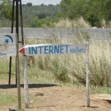 Handgeschriebenes „INTERNET 100m"-Schild am Wegesrand