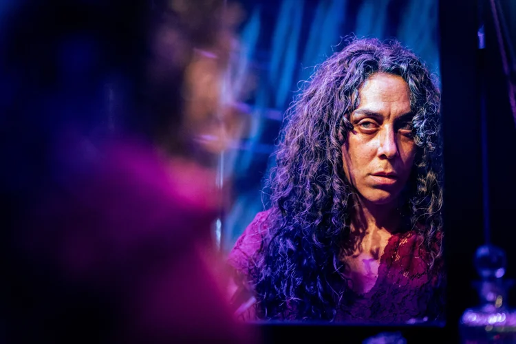 A dramatic close-up portrait under stage lighting