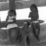 Kinder sitzen auf einer Mauer