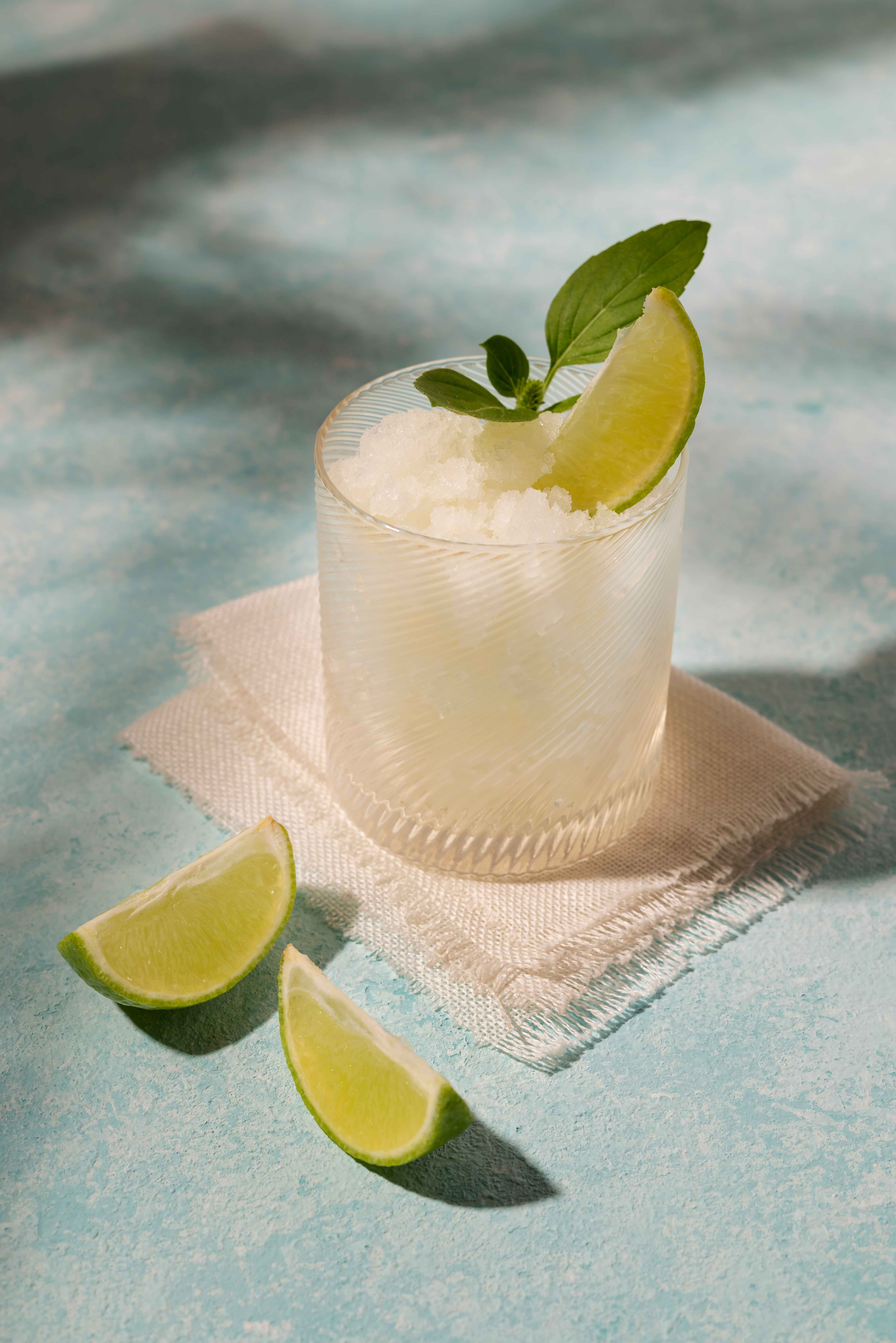 Frozen lime margarita in a fluted glass with mint and lime garnish