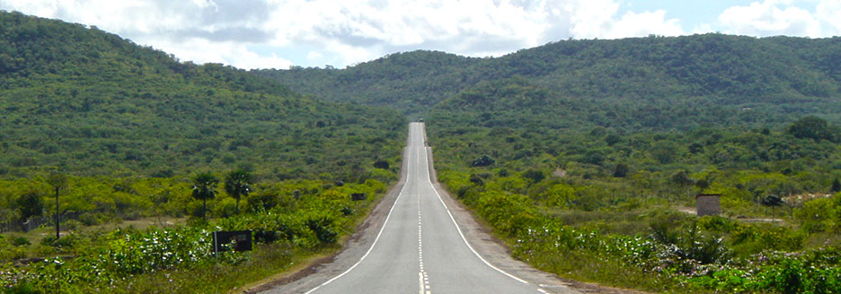 Eine lange Straße durch grüne Hügel