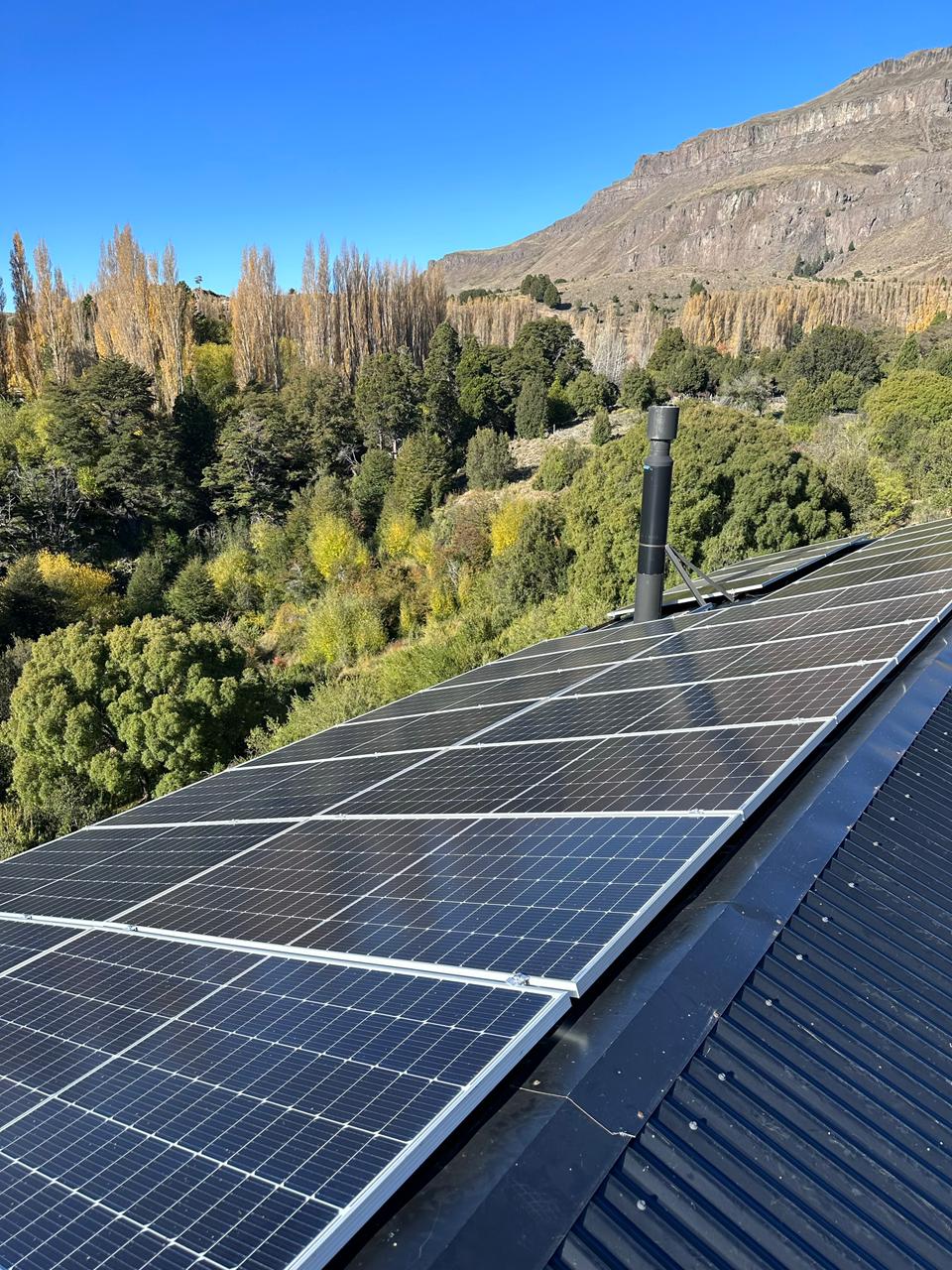 Paneles solares en terreno con valle y montañas