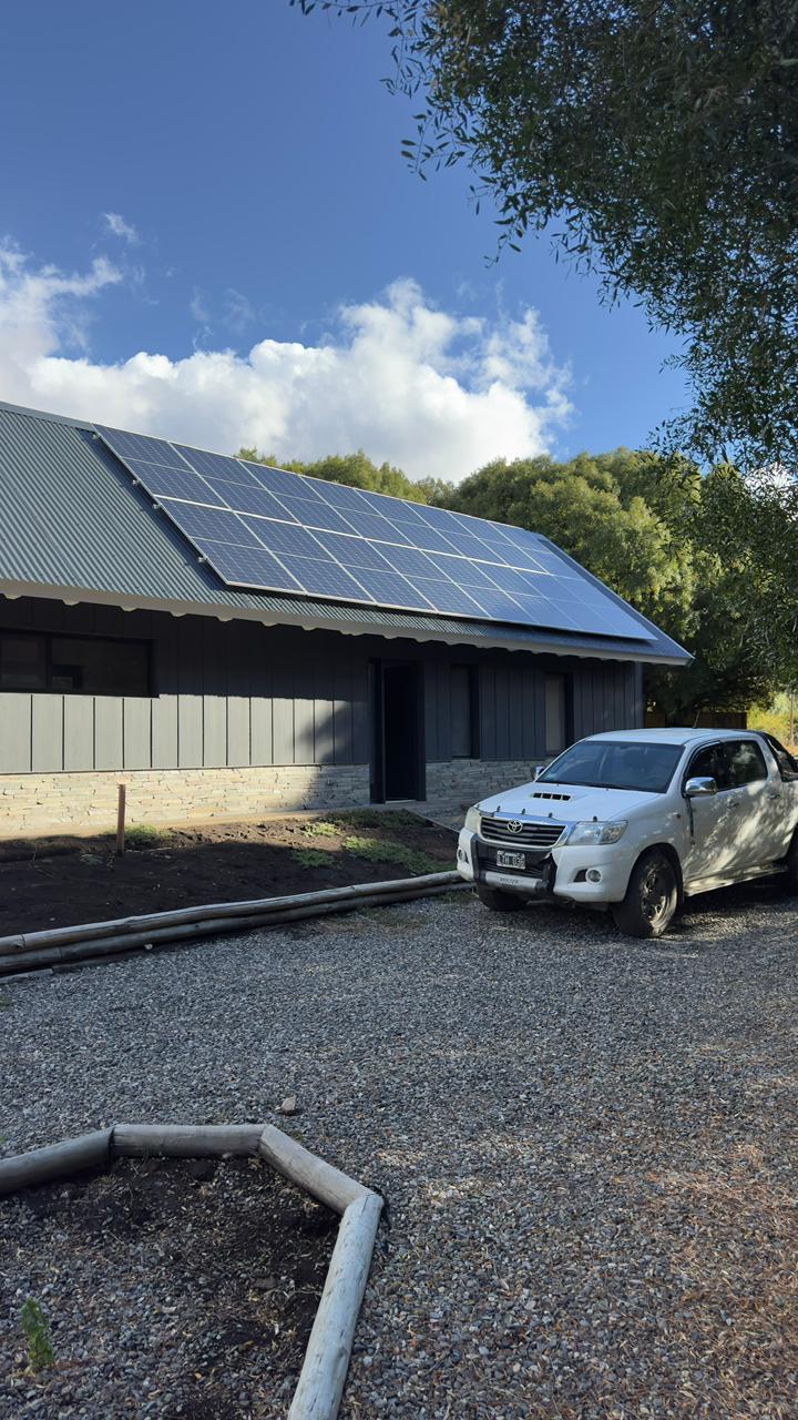 Casa con paneles solares y auto