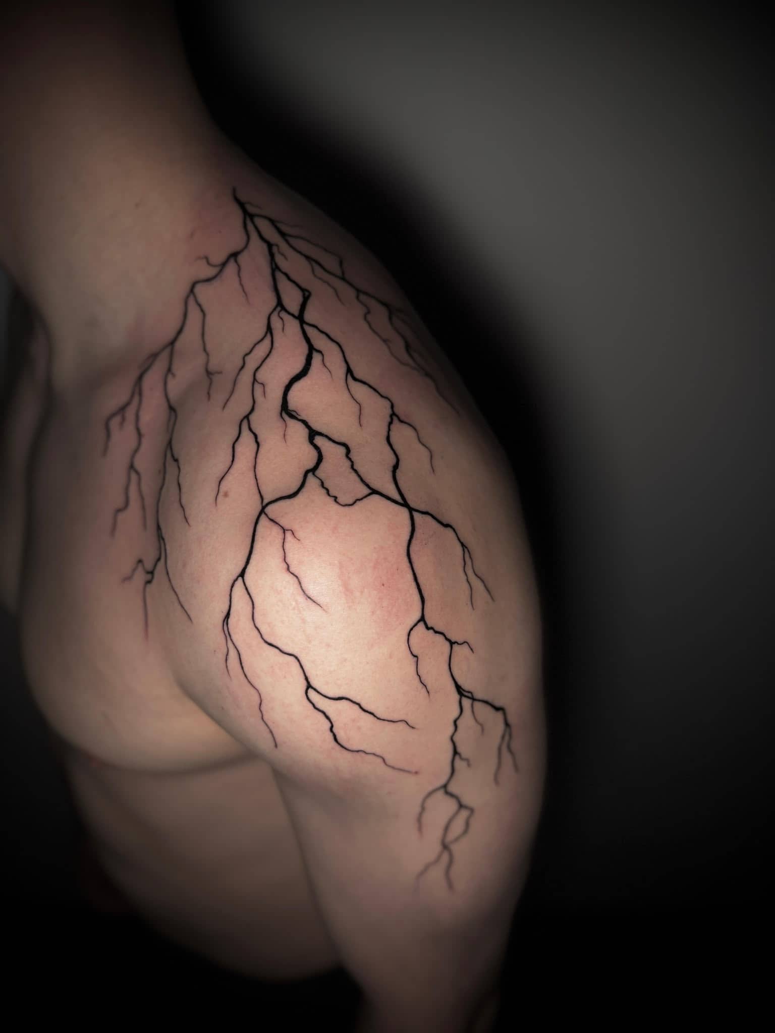 Blackwork Blitz-Risse ueber die gesamte Schulter