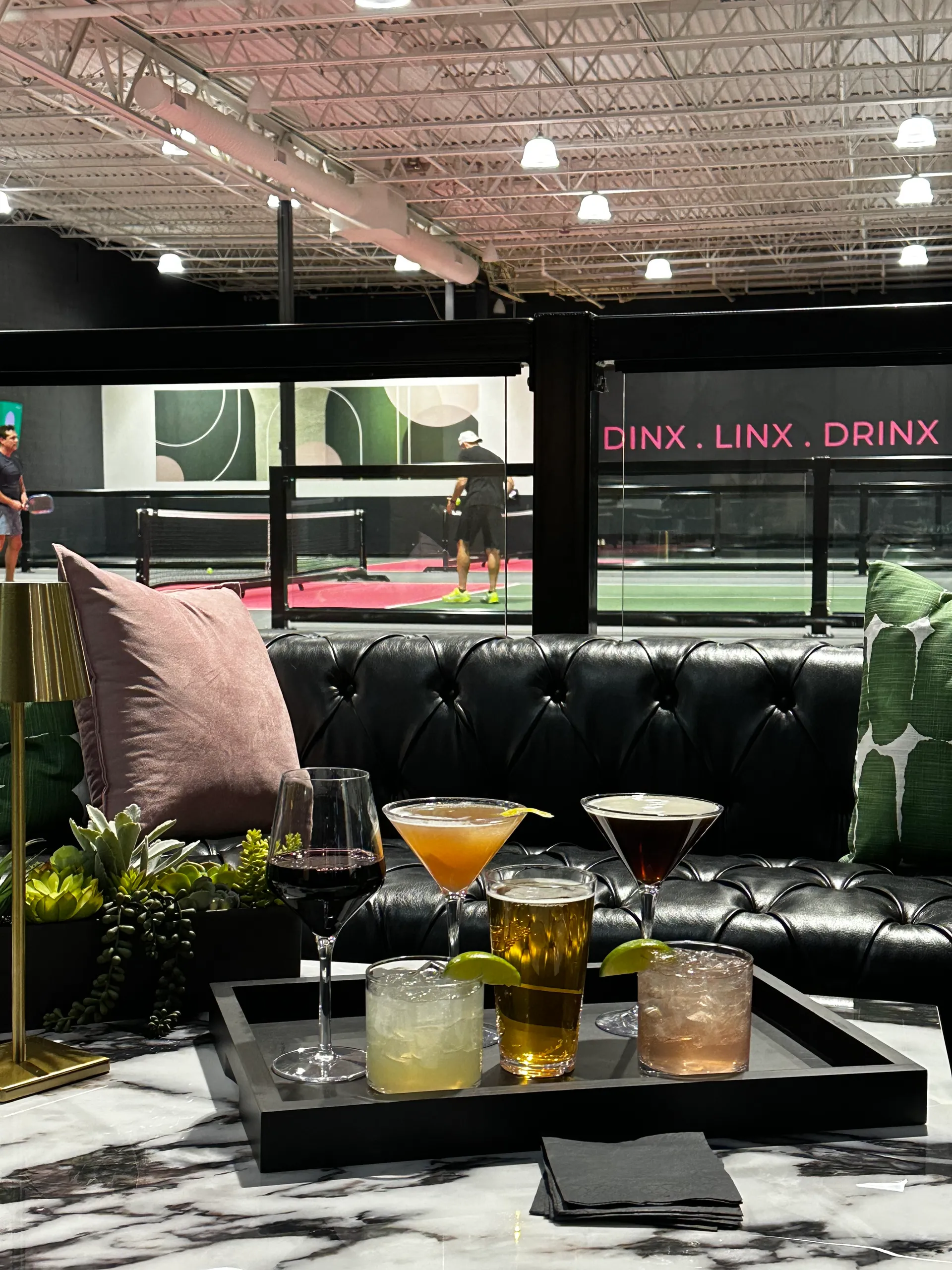 DINX Social Club lounge with cocktails and pickleball courts