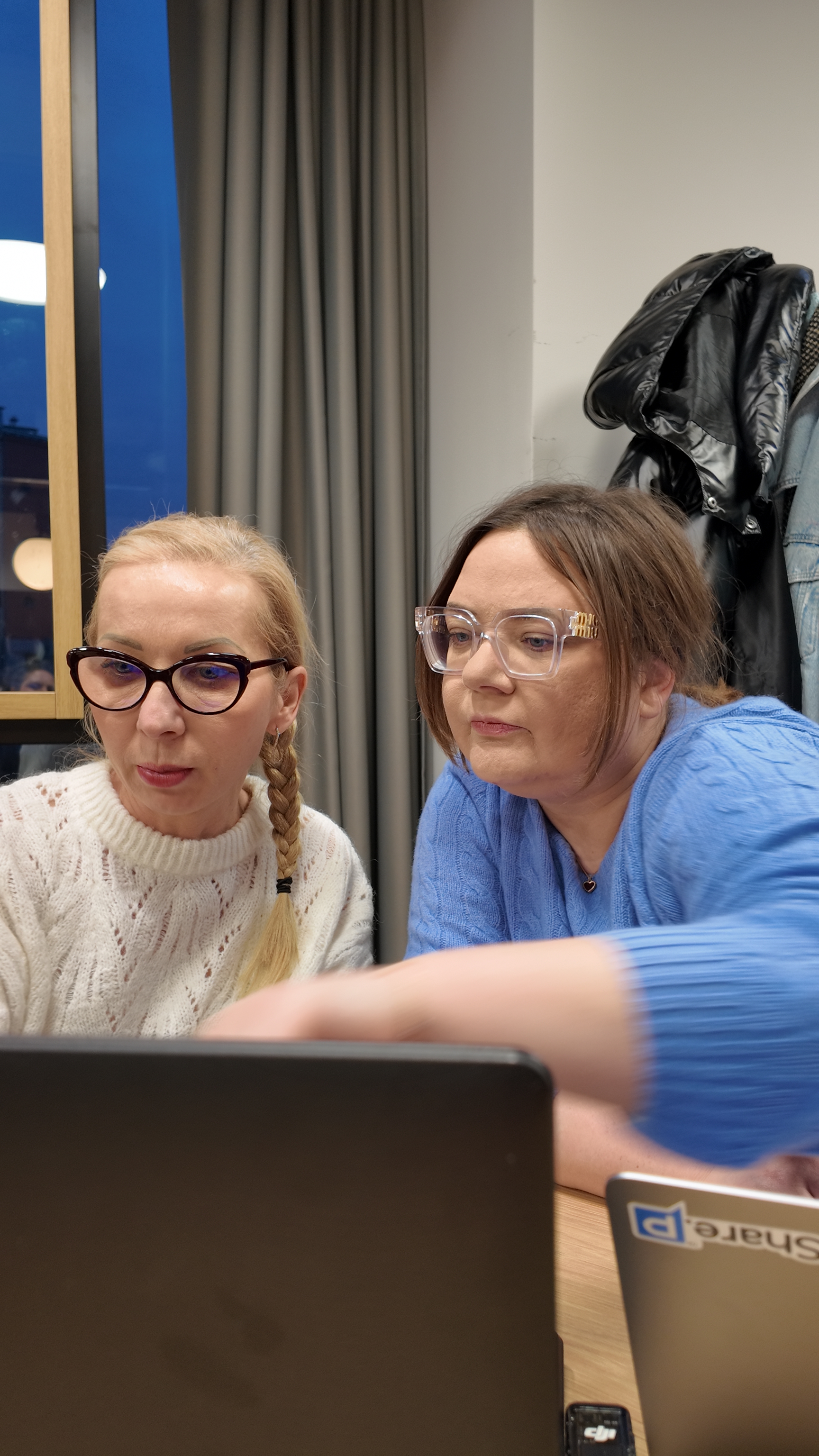 Dwie kobiety wspólnie uczą się przy laptopie podczas Cyfrowej Kawy