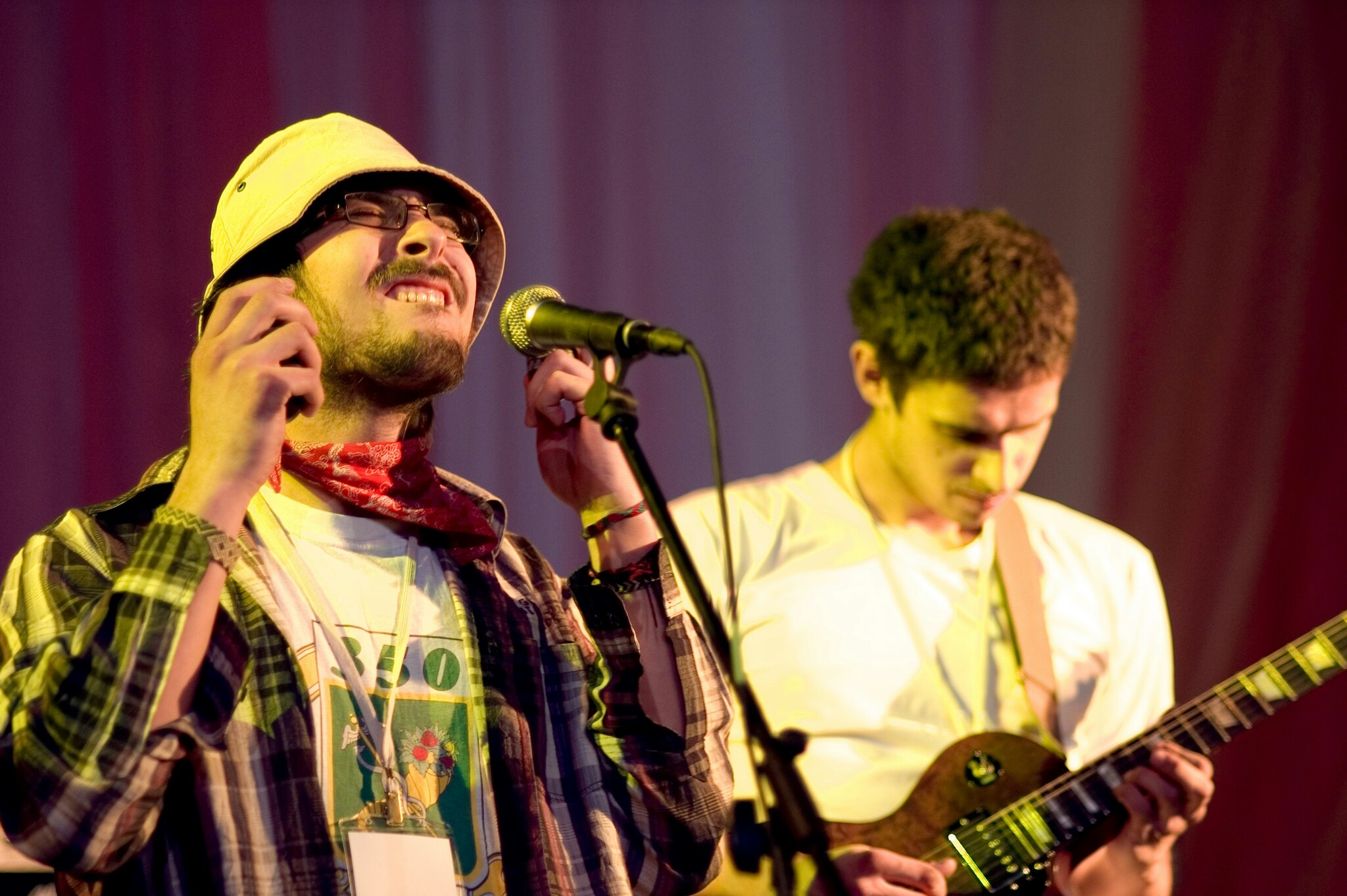 Singer at the microphone with a guitarist behind