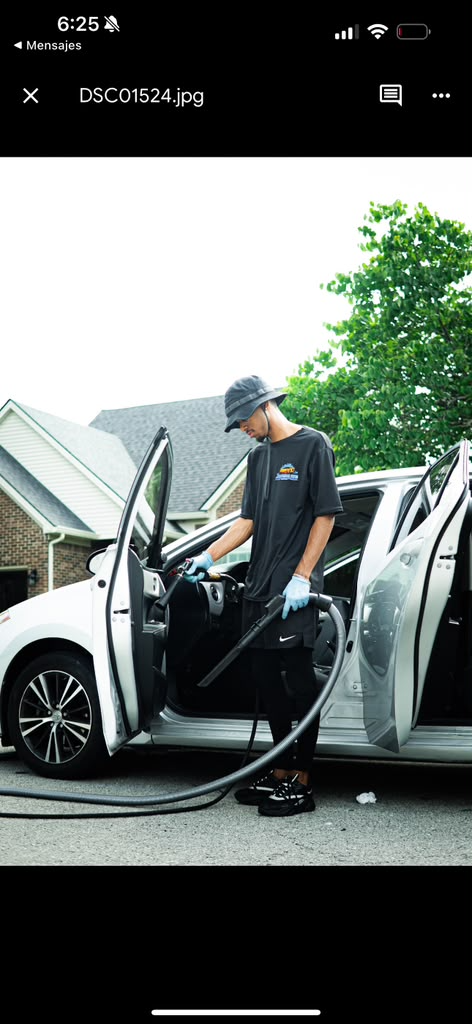 Technician vacuuming a car door interior