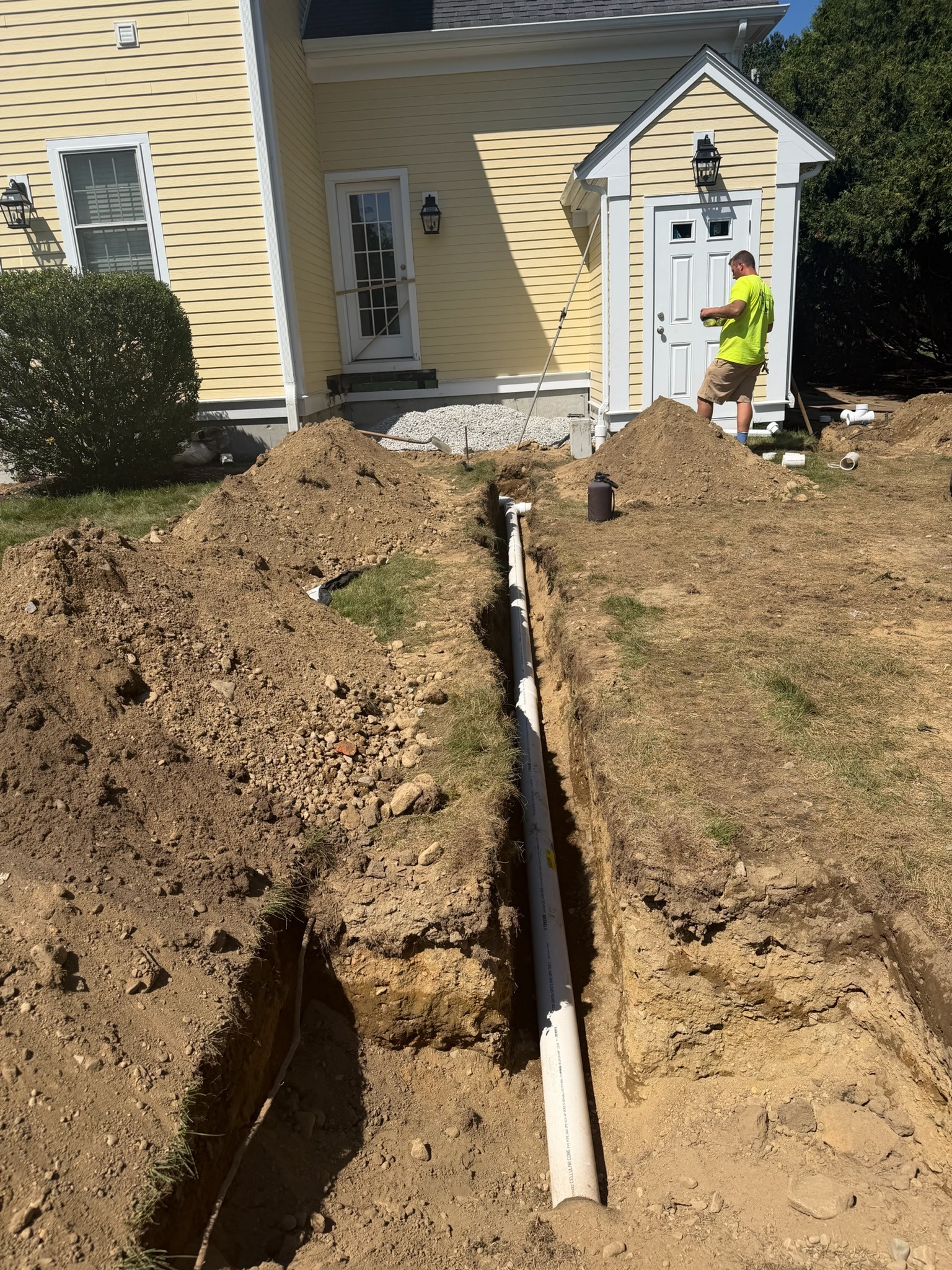 Residential downspout drainage pipe installed in a trench