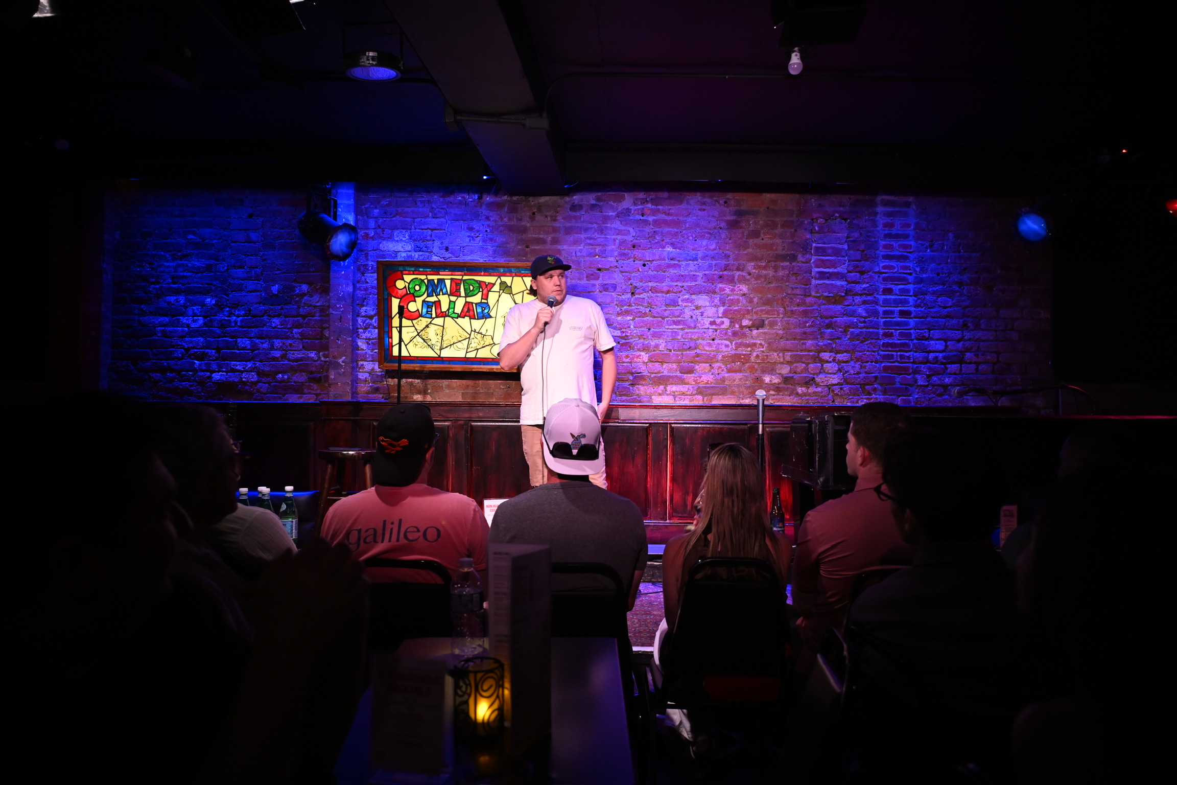 Drew Dunn performing to the audience at the Comedy Cellar