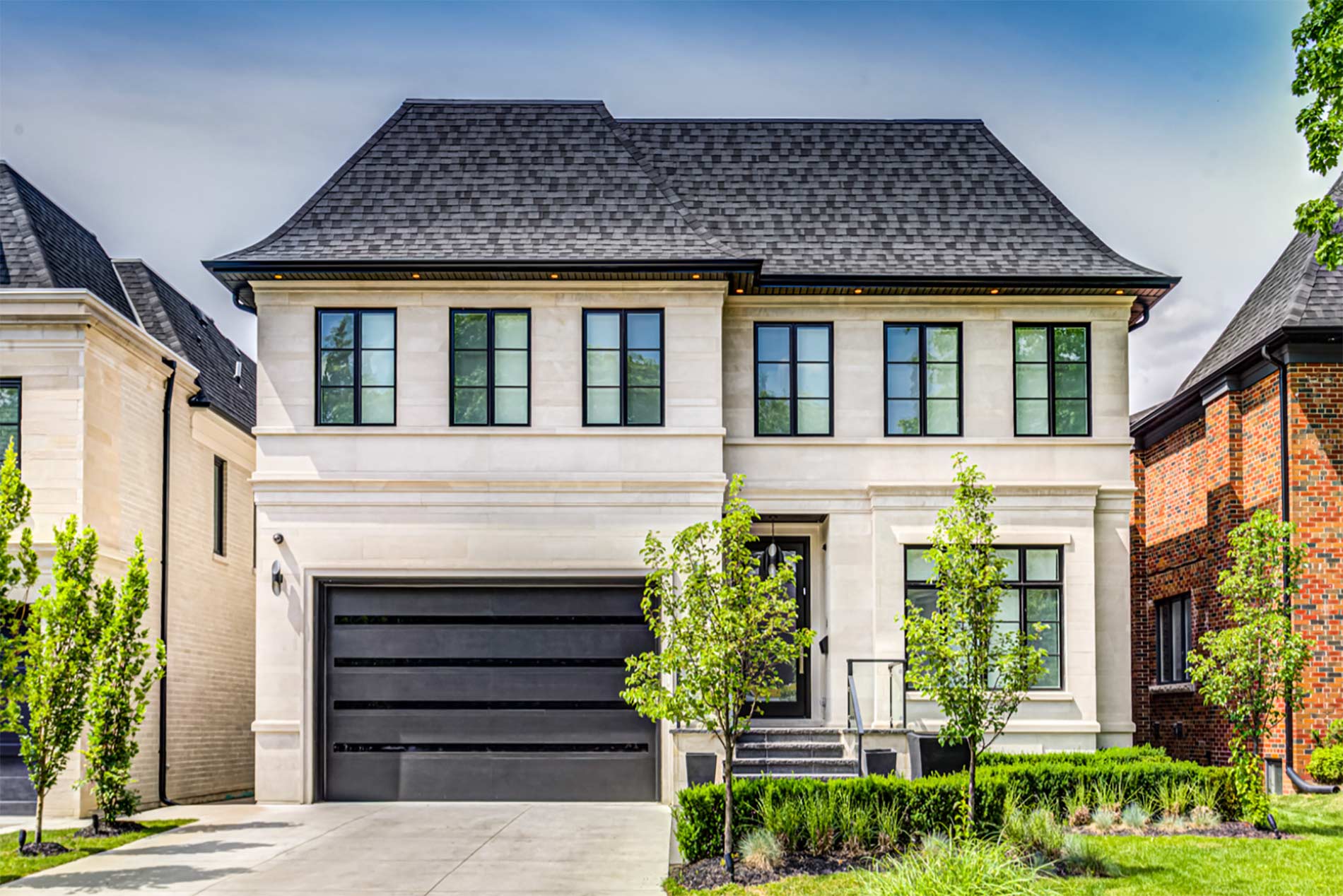 Elegant two-story stone home exterior with manicured landscaping