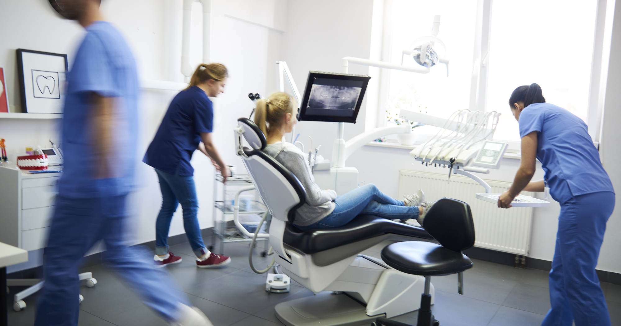 Dental team working together with a patient in the treatment room