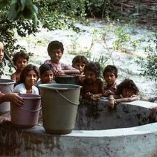 Kinder am Wassertrog mit Eimern