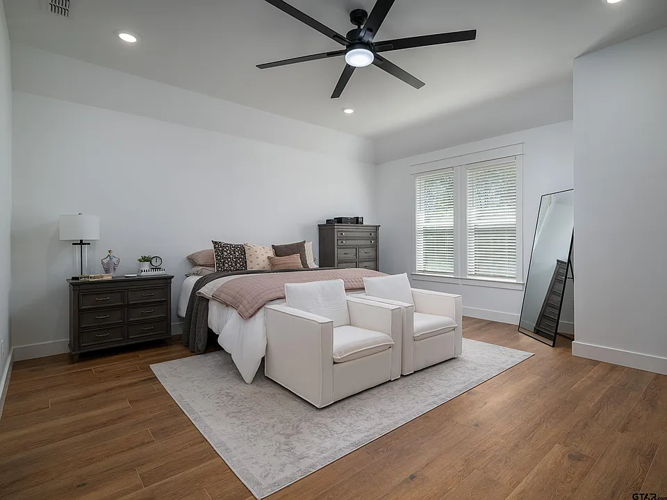 Master bedroom with ceiling fan and hardwood floors
