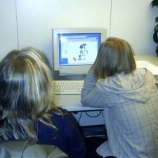 Zwei Mädchen von hinten schauen auf CRT-Bildschirm