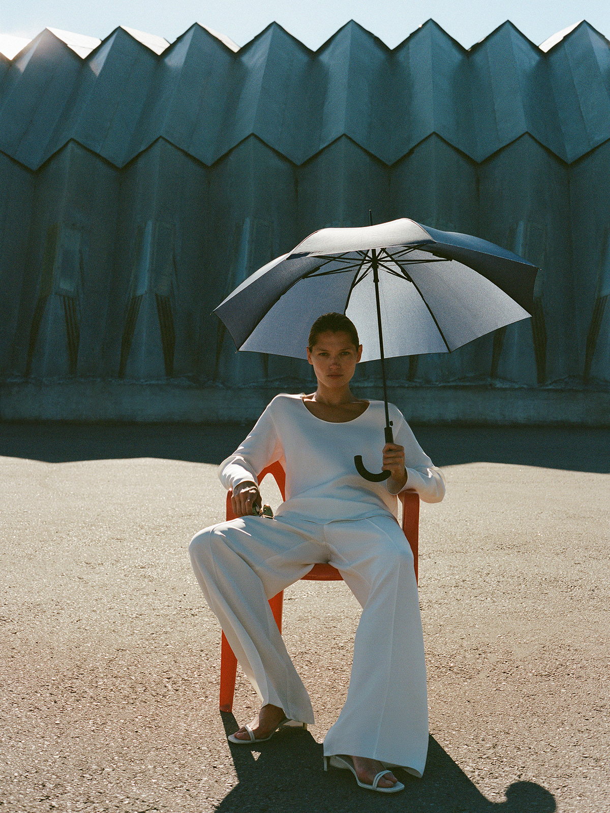 Editorial — white suit, umbrella, red chair