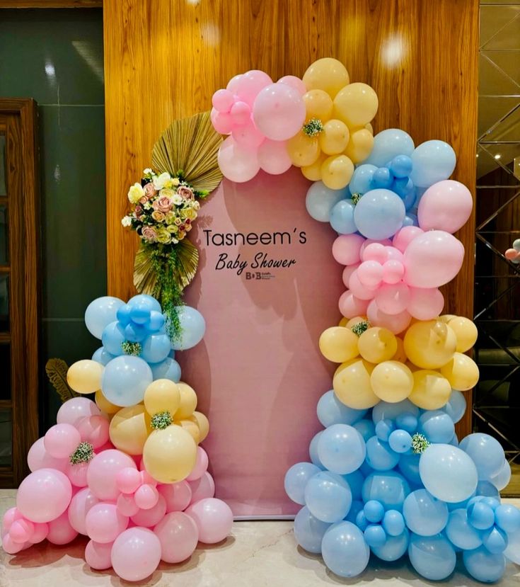 Pastel baby shower balloon arch with pink, yellow and blue colors