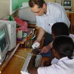 Fairnetzen-Mitarbeiter erklärt zwei kenianischen Kindern den Computer