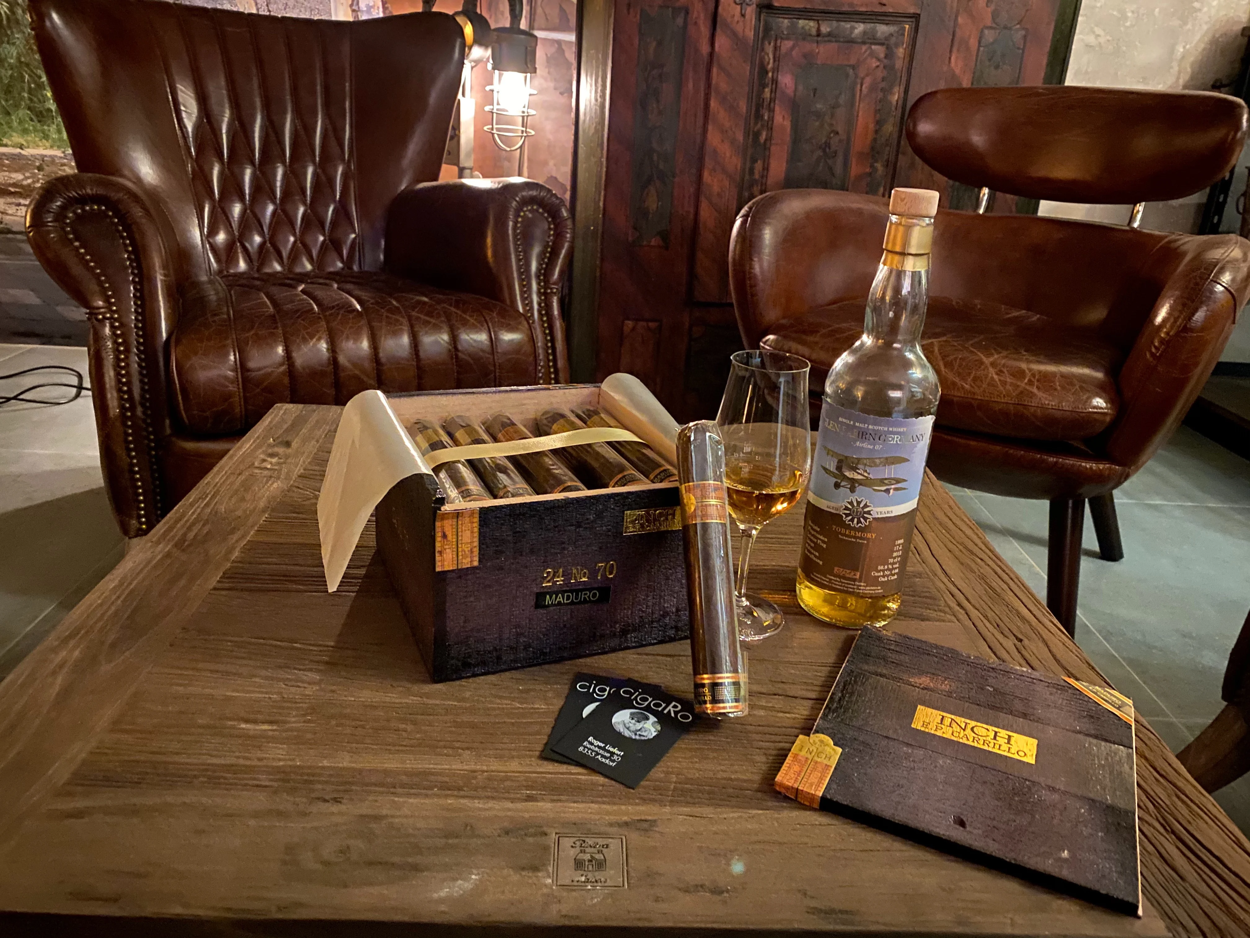 Zigarrenkiste mit Whiskyglas, Tobermory-Flasche und Visitenkarten