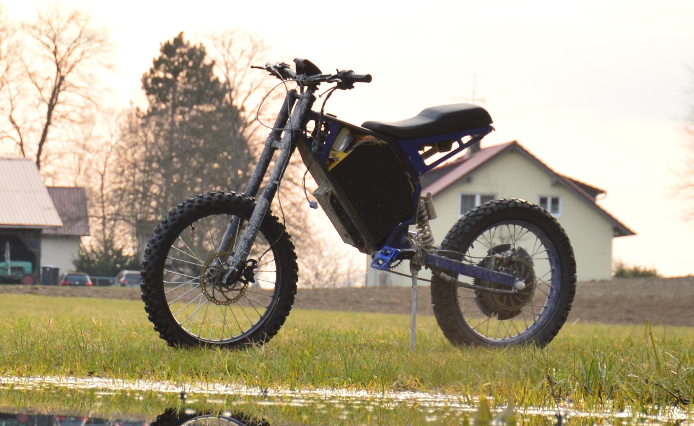 The completed high-performance electric bike captured in a cinematic sunset shot