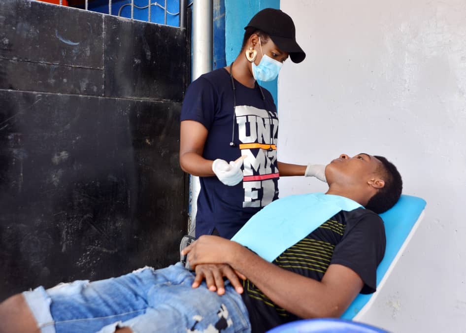 Dental practitioner examining patient on portable chair