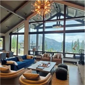 Modern mountain home interior with large tinted windows and sweeping mountain views