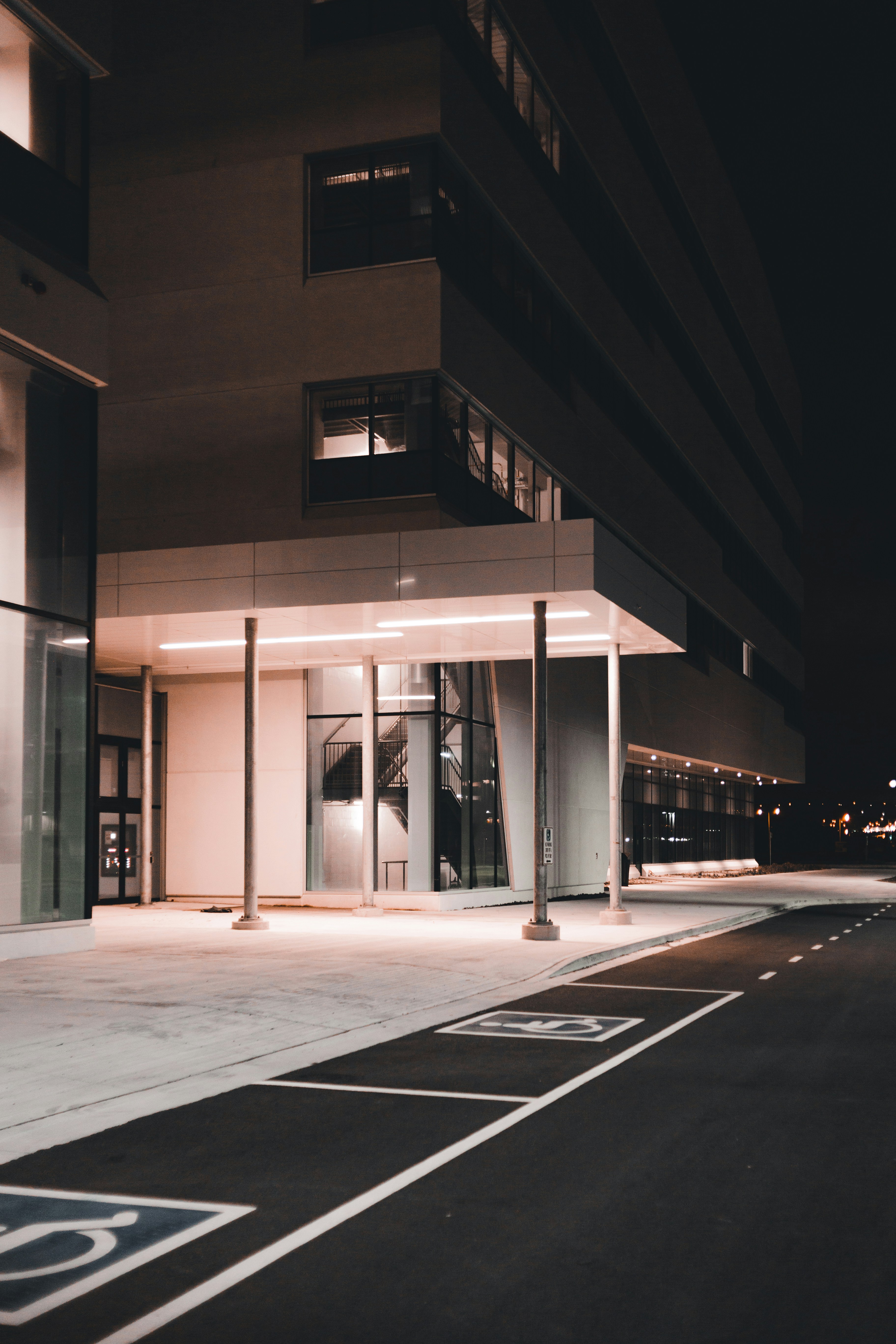 Modern commercial building entrance with warm lighting at dusk