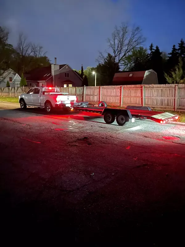 Black car being loaded onto 7x20 car hauler trailer with ramps