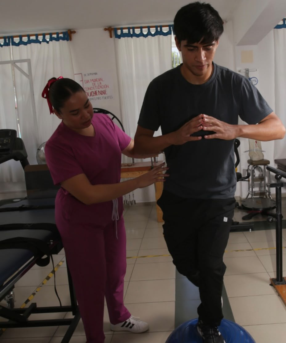 Alexia Becerra acompañando a un paciente durante un ejercicio de rehabilitación