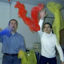 Jugendkurs: Mann und Frau werfen bunte Tücher in die Luft