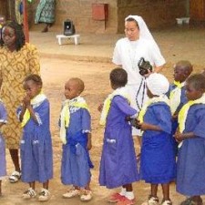 Ordensschwester fotografiert Kindergartenkinder im Schulhof