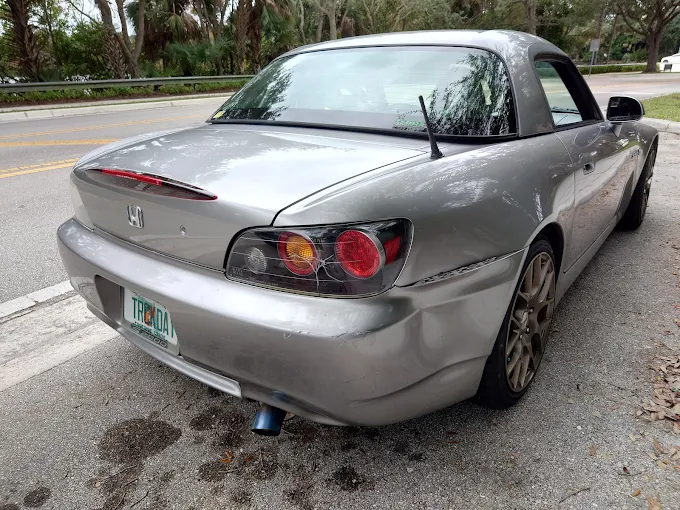 Silver Honda S2000 with rear quarter panel collision damage awaiting repair at Factory Finish