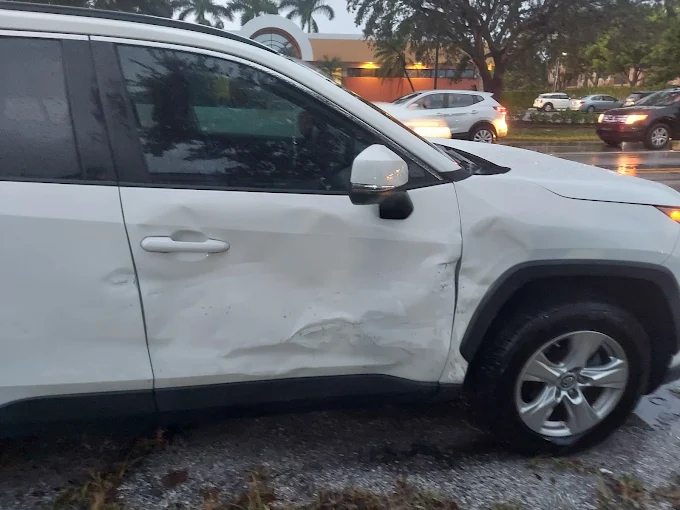 White Toyota RAV4 with significant side-impact collision damage at Factory Finish