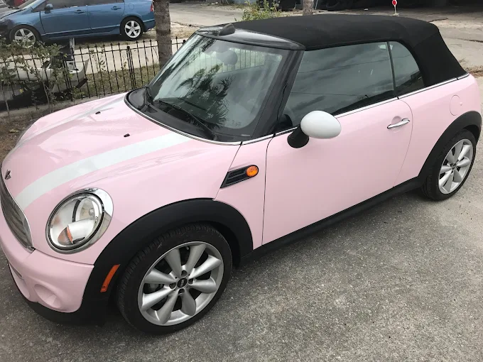 Pink convertible Mini Cooper with white racing stripe finished at Factory Finish Paint and Body
