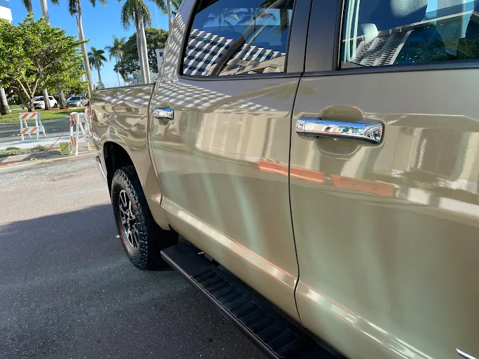 Tan Toyota Tundra side panel close-up showing a flawless paint reflection finished at Factory Finish