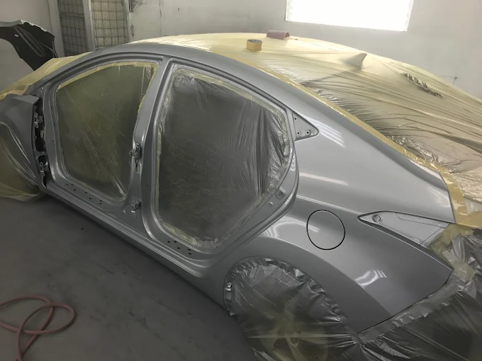 Silver Hyundai Elantra masked and prepped for refinishing inside the Factory Finish spray booth