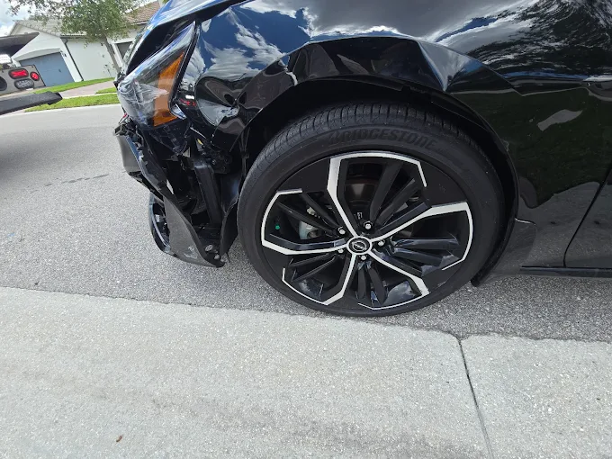 Close-up of a sedan rear quarter and alloy wheel being assessed at Factory Finish