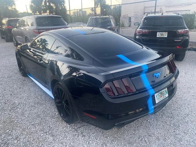 Black Ford Mustang with custom blue racing stripes painted at Factory Finish