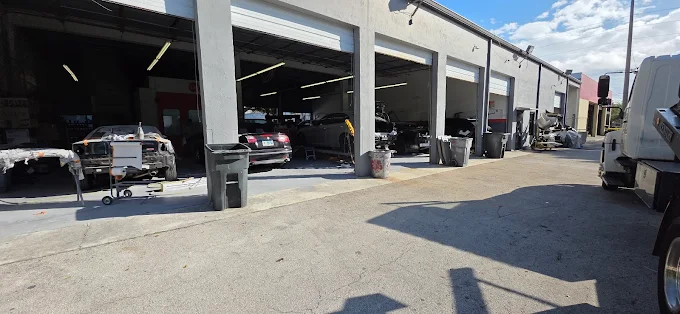 Factory Finish Paint and Body shop with all bays open and vehicles being serviced in Lake Worth Beach FL