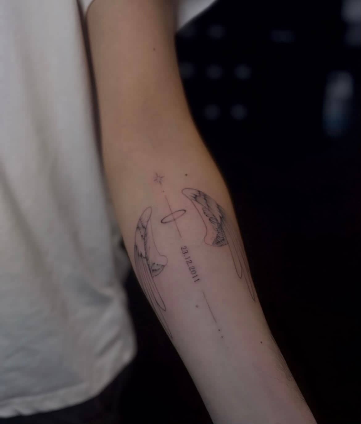 Fineline Sternzeichen-Tattoo mit Datum am Unterarm